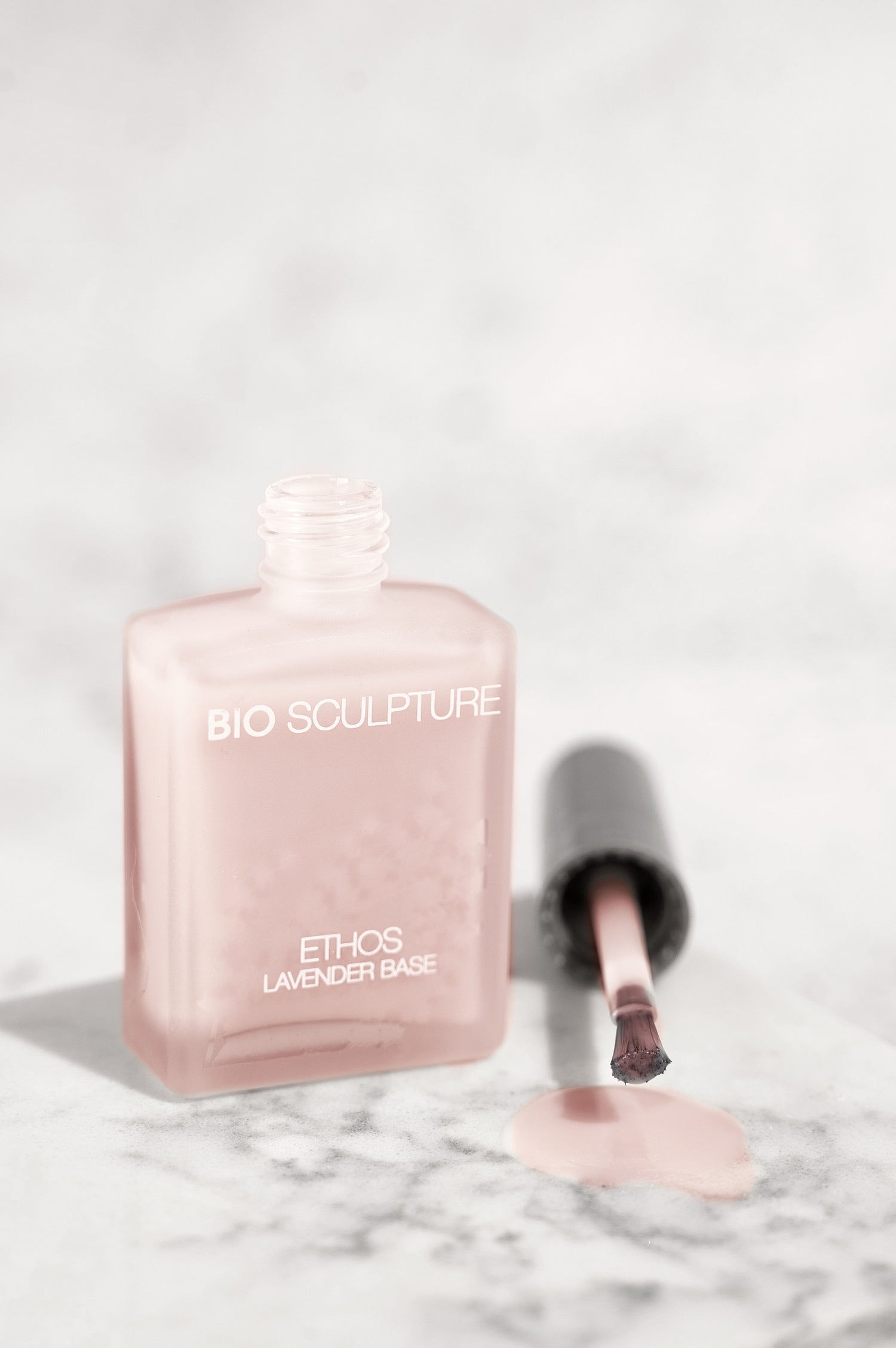 Eine Flasche ETHOS Lavender Base,der Pinsel liegt daneben und tropft